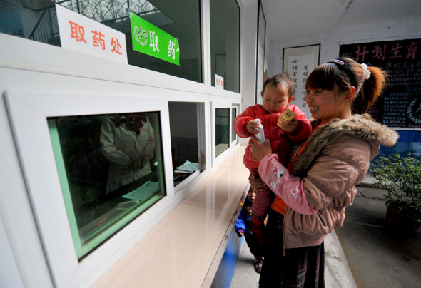 A woman collects medication prescribed after a free checkup as part of a 