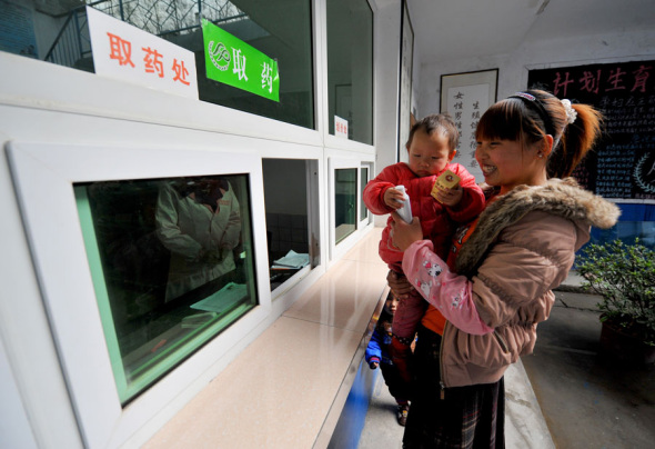 A woman collects medication prescribed after a free checkup as part of a Healthy Mother program launched by Langao county in Shaanxi province. (Photo/Xinhua)