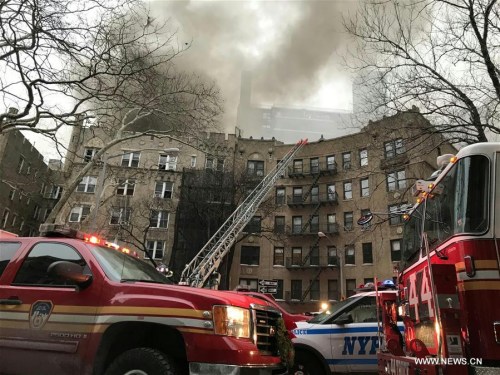 Vehicles of Fire Department of New York (FDNY) gather at the site where a fire broke out in Manhattan, New York, the United States, on Jan. 8, 2018. Fourteen people were injured in a fire at an apartment building in Manhattan in New York City on Monday afternoon, according to the New York Fire Department. (Xinhua/Wang Ying)