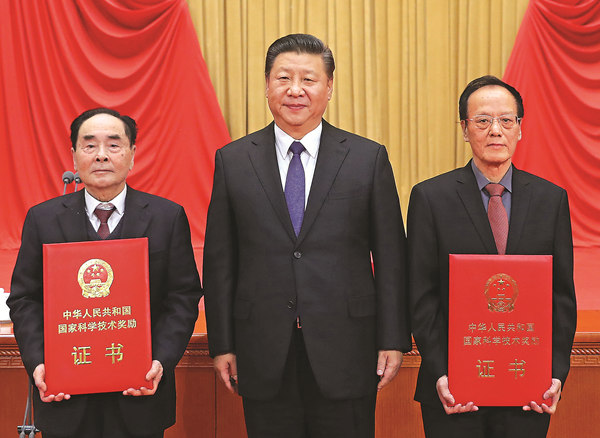 President Xi Jinping stands between Hou Yunde (left) and Wang Zeshan, who won China's top science award on Monday for their outstanding contributions to scientific and technological innovation, at the Great Hall of the People in Beijing. (Photo/Xinhua)