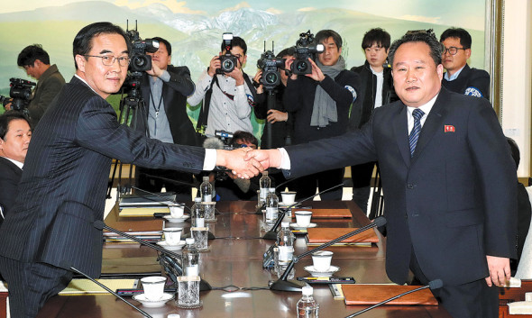 Ri Son-gwon (right), chairman of the Committee for the Peaceful Reunification of the Fatherland of the Democratic People's Republic of Korea, shakes hands with Unification Minister Cho Myoung-gyon of the Republic of Korea in the truce village of Panmunjom on Tuesday. Photo/Xinhua