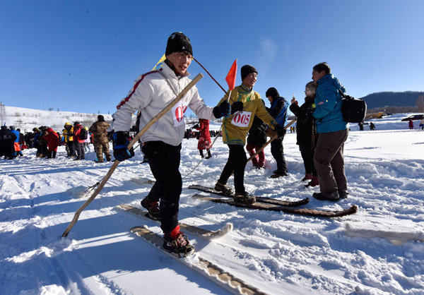 Visitors try traditional Kazakh wooden skis at Hemu village in Altay prefecture, Xinjiang Uygur autonomous region. (Photo/Xinhua)