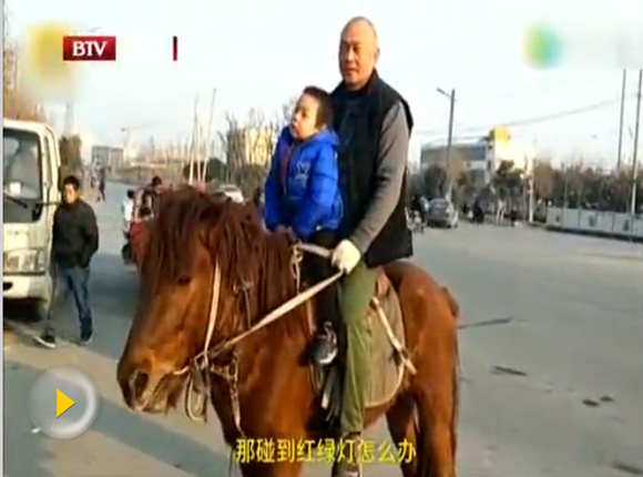 A man picks up his son by horse from kindergarten in Xianyang, Northwest China's Shaanxi province, Jan 12, 2018. (Photo/Video screenshot from BTV)