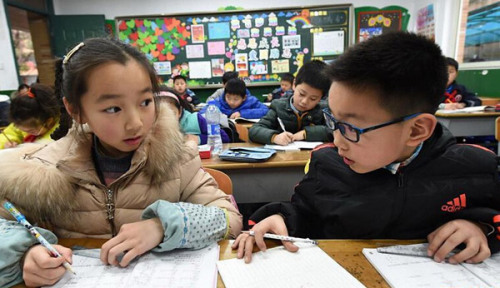 Primary school students do their homework in a classroom after school in Nanjing, Jiangsu Province, in February. (Photo/Xinhua)
