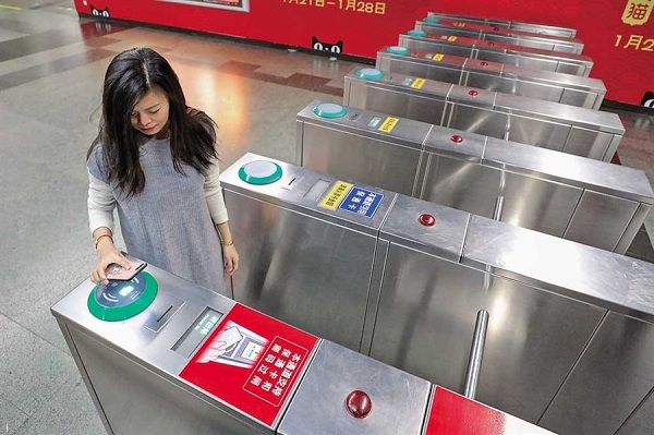 A woman uses her cellphone to pay Metro fare at the Peoples Square Station yesterday. Payment by scanning a QR code via mobile phones will be available in all 389 Metro stations in Shanghai this Saturday. (Jiang Xiaowei)