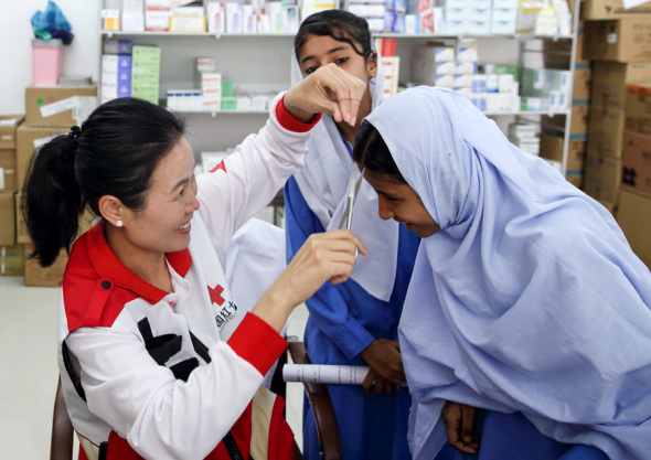 Fu Wenhuan, a doctor with the Chinese Red Cross foreign aid medical team takes a hair sample as part of checkups given to students from the China-Pakistan Government Primary School Faqeer Colony in Gwadar, Pakistan, on Wednesday.（Photo by WANG JING/CHINA DAILY）