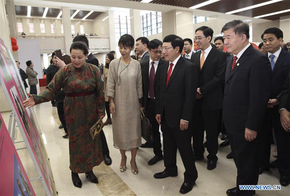 Chen Zhu (1st R, front), Vice Chairman of China's National People's Congress Standing Committee, and Pham Binh Minh (2nd R, front), Vietnamese Deputy Prime Minister and Foreign Minister, visit a photo exhibition during a reception marking the 68th anniversary of the establishment of diplomatic relations between China and Vietnam as well as the upcoming Spring Festival in Hanoi, Vietnam, Jan. 20, 2018. (Xinhua/Wang Di)