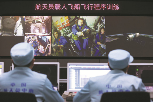 Astronauts Chen Dong (from left), Liu Wang and Liu Yang receive orders from mission control technicians during a training procedure in Beijing this month. (Photo/CHINA DAILY)