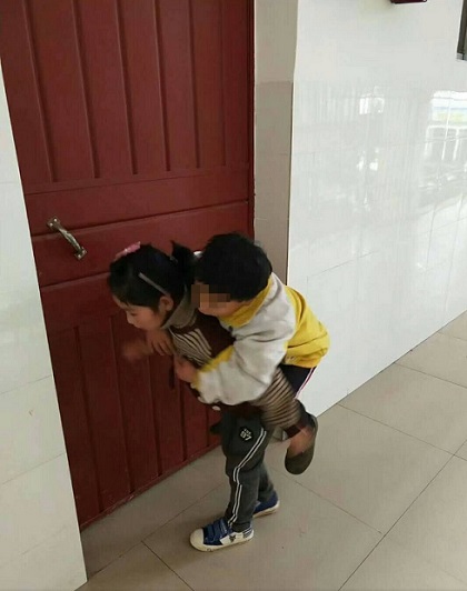 Zhou Dingshuang carries her elder brother to school every day. (Photo provided to chinadaily.com.cn)