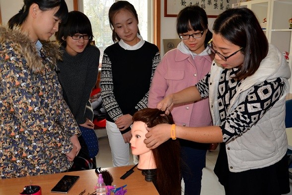 A trainer shows volunteers how to dress hair at an NGO incubator park in Jinan, Shandong province. (Photo Provided To China Daily)