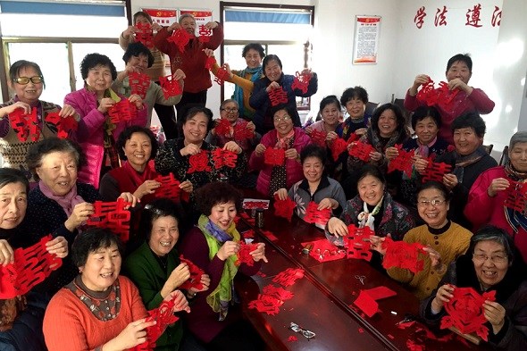 Seniors display paper-cuts made under the guidance of volunteers from Raindrop, an NGO in Jinan. (Photo Provided To China Daily)