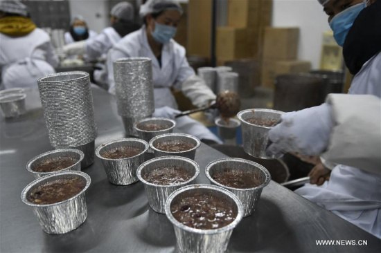Voluntary workers fill bowls with Laba porridge at the Lingyin Temple in Hangzhou, east China's Zhejiang Province, Jan. 23, 2018. (Xinhua/Huang Zongzhi)