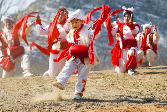 Xiao Jiapeng, 6, performs a waist drum dance with other villagers in Ansai district, Yan'an, in Shaanxi province on Jan 17. The colorful community is finding prosperity through its 'can do' attitude. (Zhu Xingxin/China Daily)