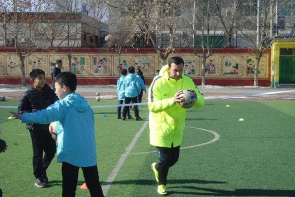 One of the coaches from Football Club Internazionale Milano teaches soccer at Xiongxian No 1 Primary School in North China's Hebei province, Jan 29, 2018. (Photo provided to chinadaily.com.cn)
