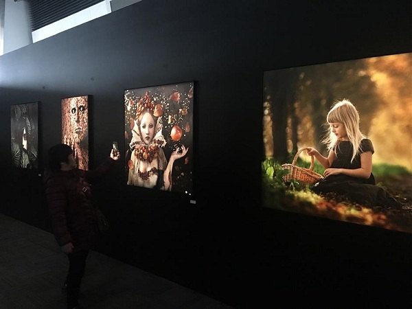 A visitor captures a few of the stunning images on show at the Shanghai World Financial Center on his mobile phone. (Yang Jian/SHINE)