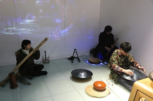 Li Yunke (right) plays a steel tongue drum (Photo provided to China Daily)