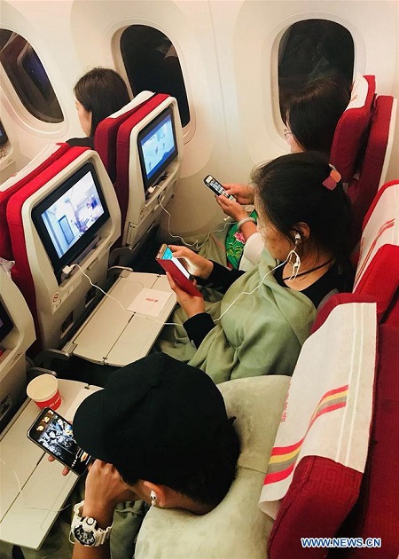 Passengers use mobile phones with inflight wifi connections on board the flight HU7781 of Hainan Airlines, Jan 18, 2018. (Photo/Xinhua)