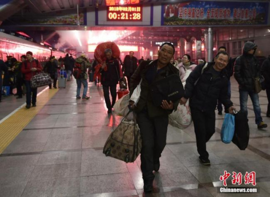 Passengers with heavy luggage at the Beijing Railway Station on February 1, 2018. [Photo: Chinanews.com]