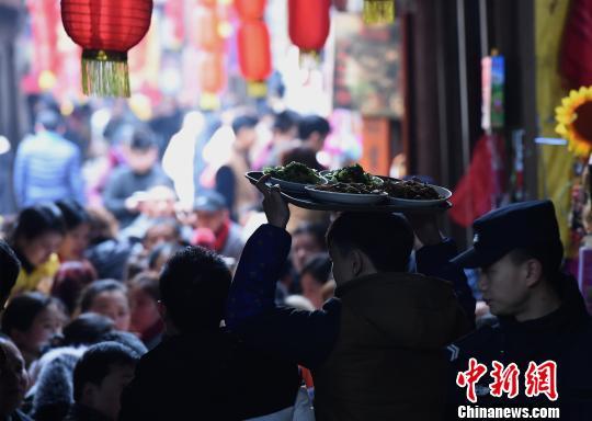 Local residents send self prepared food to the banquet for the relatives and tourists to taste in the old town of Zhongshan in Chongqing City on Feb 3, 2018.. [Photo: chinanews.com]