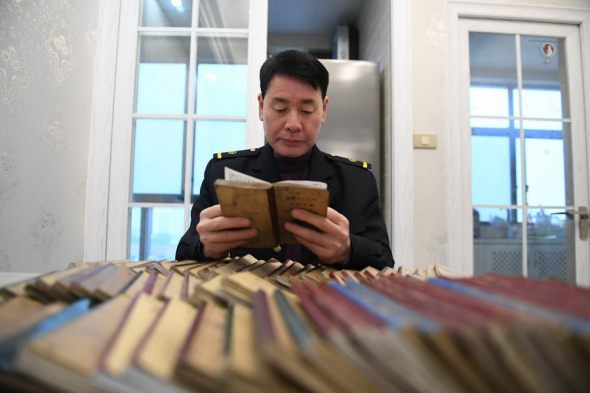 Yu Xiangyang, a train driver in Yingtan, Jiangxi province, reads a notebook on Jan 30, 2018. (Photo/Xinhua)