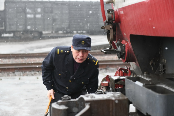 Yu Xiangyang checks a locomotive on Jan 31, 2018.  (Photo/Xinhua)
