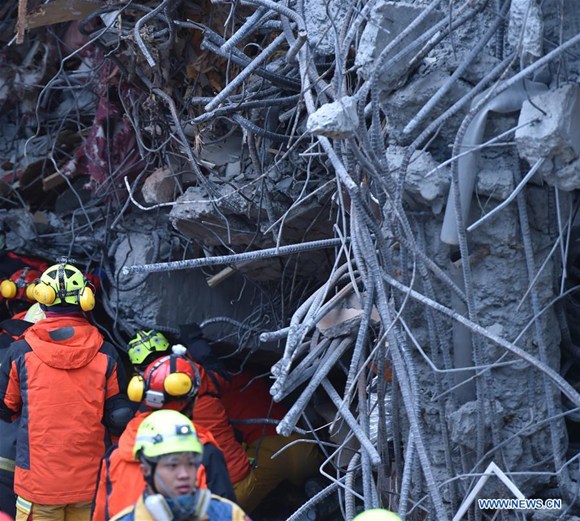 Rescuers work in front of a collapsed building in quake-hit Hualien County, southeast China's Taiwan, Feb. 7, 2018. Four people were killed and 225 were injured as of 10:40 a.m. Wednesday after a 6.5-magnitude earthquake hit Taiwan. (Xinhua/Yue Yuewei)