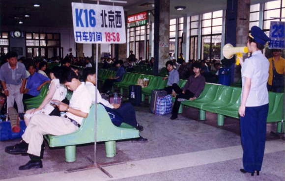 A staff member prompts passengers to get on the train in the waiting room of Guangzhou Railway Station in the early 1990s. (Photo/Courtesy of Guangzhou Railway Station)