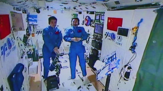 Photo provided by Astronaut Center of China shows Chinese astronauts Jing Haipeng (R) and Chen Dong accept their first earth-space interview in Tiangong-2, Nov. 15, 2016. (Photo/Xinhua)