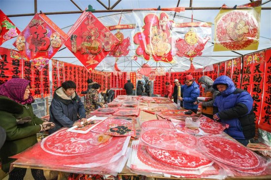 People select Spring Festival goods at a grand fair in Yingkou City of northeast China's Liaoning Province, on Feb. 8, 2018, the day of Xiaonian (small year). Xiaonian falls on the 23rd or 24th day of the last month of the Chinese traditional lunar calendar, marking the start of the countdown to Spring Festival. (Xinhua/Pan Yulong)