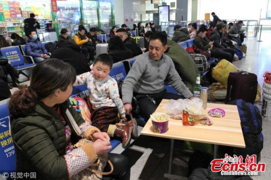 A boy and his grandparents have instant noodles at a railway station in Jinan City, the capital of East Chinas Shandong Province. (Photo/VCG)