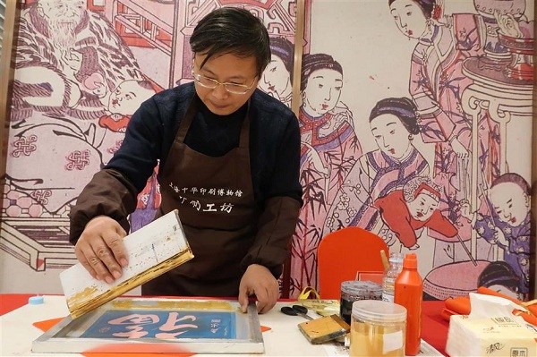 An artist shows on the site how to make a woodblock print. (Wang Rongjiang/SHINE)