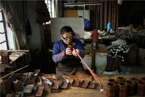 Gu Yue, a well-known company in Wuxi that produces erhu, is home to dozens of middle-aged artisans who painstakingly assemble each erhu by hand. (Photo by Alywin Chew/China Daily)