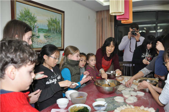 Wu Yanheng teaches children to make dumplings. She founded a volunteer group to help expats and their families settle in Wuxi, Jiangsu province, in 2008. (Photo provided to China Daily)