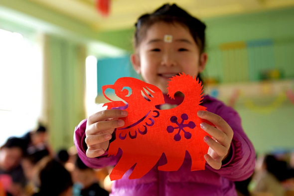 A child from Hengshui, Hebei presents her paper-cut work.[Photo by Wang Xiao/Xinhua]