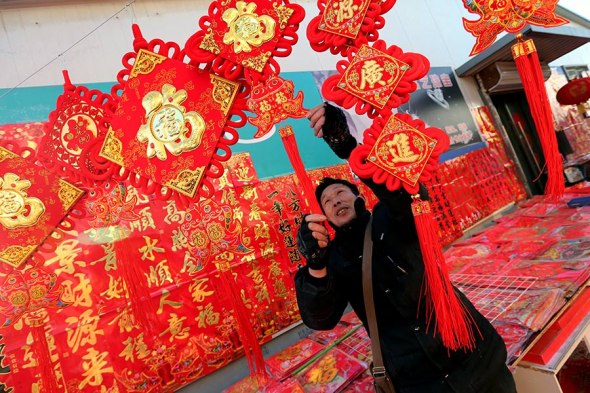 A vendor at Beijing's Chaolai wholesale market sells Spring Festival couplets. (Photo by Wang Zhuangfei/China Daily)