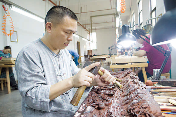 Hu Xianmin is an inheritor of the craft of Dongyang wood carving, which was in 2006 listed as a national intangible cultural heritage. (PHOTOS BY GAO ERQIANG\CHINA DAILY)