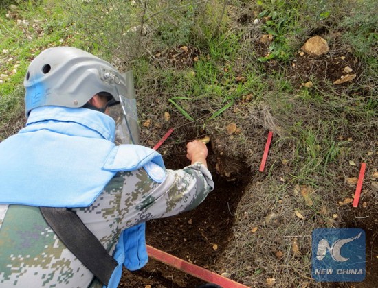 A Chinese peacekeeper in the UNIFIL was carefully clearing the dirt covering a land mine planted along the UN Blue Line between Israel and Lebanon, on Feb. 5, 2018. (Xinhua)
