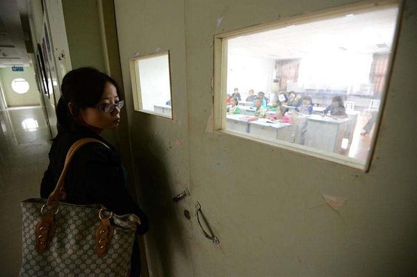 A mother waiting outside classroom keeps an eye on her child. (SHINE)