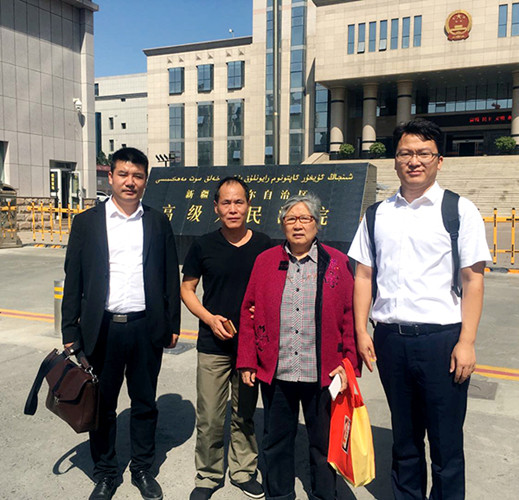 Zhou Yuan (second from left) stands in front of the Xinjiang High People's Court in Urumqi, during a retrial in August. He is accompanied by Li Bizhen, his mother, and lawyers Liu Zheng (left) and Wang Xing (right). (Photo provided to China Daily)