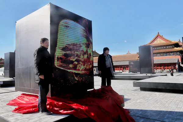 Shan Jixiang (left), director of the Palace Museum in Beijing, unveils the National Treasure exhibition on Monday together with television director Yu Lei. (Photo by Jiang Dong / China Daily)