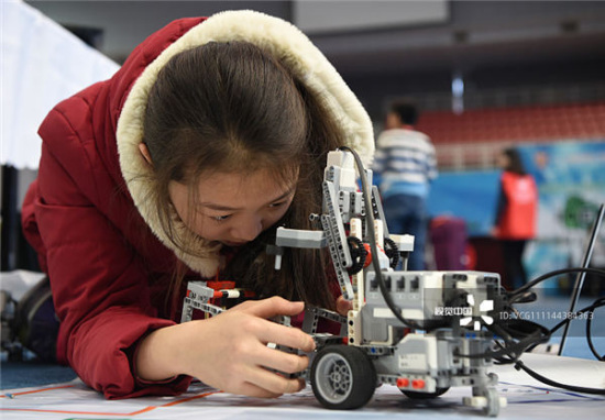 A competitor debugs a robot during the Roborave Asia 2018 held in Beijing. [Photo by Hou Yu/China Daily]