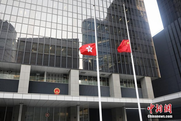 Hong Kong's top officials paid silent tribute on Tuesday to the victims of the city's second-most deadly bus crash. The national flag and that of the Hong Kong Special Administrative Region were also lowered to half-staff at the city government's headquarters as a mark of respect. (Xie Guanglei/China News Service)