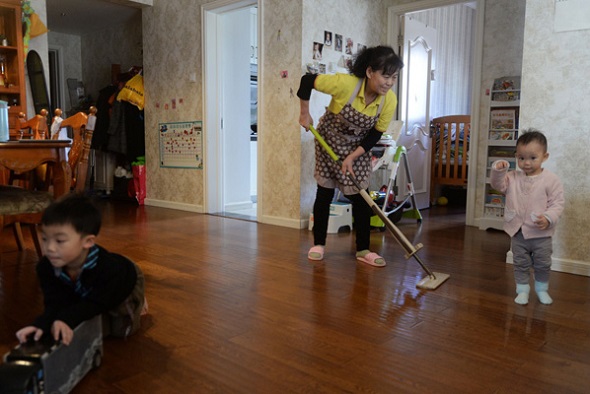 Domestic helper Cai Lianxiang works at a client's house in Beijing earlier this month. She chose to stay in the capital to work during the holiday and will receive extra salary. (Photo by Zhuang Wenbin/For China Daily)