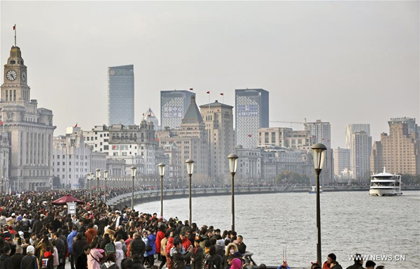 Tourists visit the Bund in east China's Shanghai, Feb. 17, 2018. The Chinese people enjoy their week-long holiday for the Spring Festival, or the Chinese Lunar New Year, which fell on Feb. 16 this year. (Xinhua/Zhuang Yi)