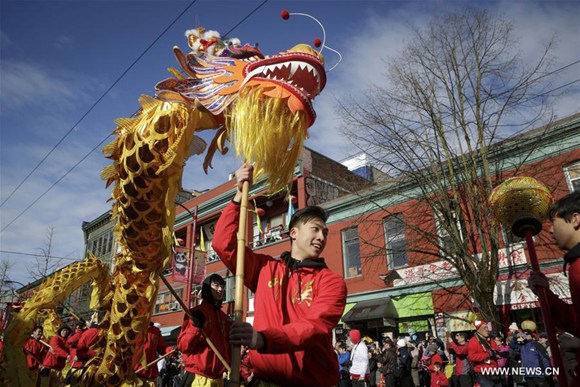 Participants perform dragon dance during the 45th Chinese New Year Parade in Vancouver, Canada, on Feb. 18, 2018. Thousands of participants paraded along the streets in Vancouver's Chinatown Sunday to celebrate the Year of the Dog, attracting over 100,000 spectators. (Xinhua/Liang Sen)