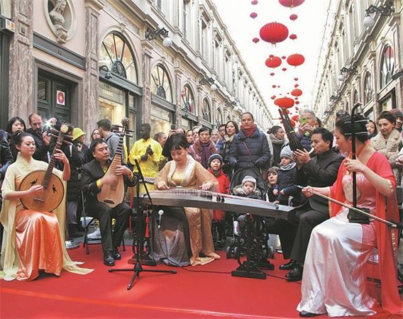 Chinese and Belgian artists perform at the lantern-hanging ceremony at the Saint-Hubert Royal Galleries in Brussels on the first day of Chinese New Year on Feb 16. Observing the Chinese tradition has become more common around the world. (WU NIAN / CHINA DAILY)