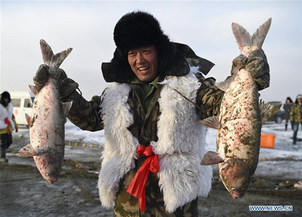 A fisherman shows fish during winter fishing at Wolong Lake of Kangping county, Northeast China's Liaoning province, Jan 23, 2018. (Photo/Xinhua)