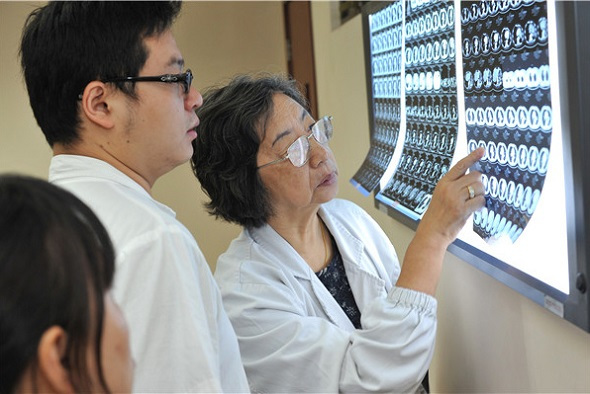 Liao Meilin (right) reads CT scans with colleagues at the Shanghai Chest Hospital. (Photo provided to China Daily)