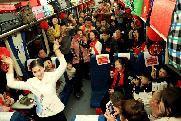 Government employees from Fuyang, Anhui province, provide entertainment on a train on Feb 7 informing passengers about the latest developments in the city. (Zhu Lixin/China Daily)