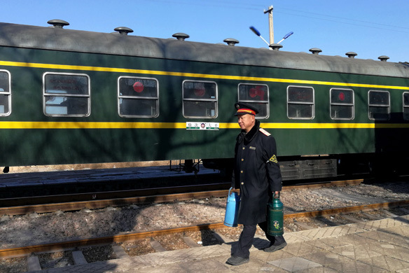 Liu Lixin, a conductor for the train connecting Yuci and Xiangyuan in Shanxi province, walks by the train on Feb. 12, 2018. (Photo by Sun Ruisheng/China Daily)